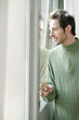 man looking out through a door glass
