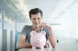 businessman inserting a coin into a piggy bank