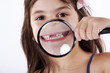 Mädchen mit Lupe zeigt Zähne, Girl with magnifying glass Mädchen mit Lupe zeigt Zähne, Girl with magnifying glass