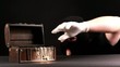 Thief stealing gold from jewel box, over black background