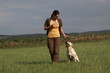 Frau mit Labrador-Retriever beim Dummytraining