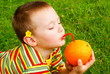 The child is drinking orange juice