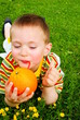 The child is drinking orange juice