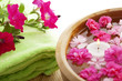Spa therapy, flowers in water, on a bamboo mat.