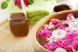 Spa therapy, flowers in water, on a bamboo mat.