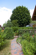 Garten mit Blumenbeet und Gartenweg eines Einfamilienhauses