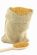 Fenugreek seeds in burlap bag and over wooden spoon. Fenugreek seeds in burlap bag and over wooden spoon.