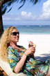 Junge Frau mit Cocktail am Strand