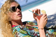 Junge Frau mit Cocktail am Strand