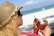 Junge Frau mit Cocktail am Strand