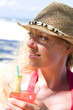 Junge Frau mit Cocktail am Strand