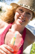Junge Frau mit Cocktail am Strand