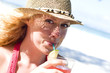 Junge Frau mit Cocktail am Strand
