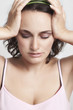 Photo: relieved young woman with closed eyes holding her head relieved young woman with closed eyes holding her head