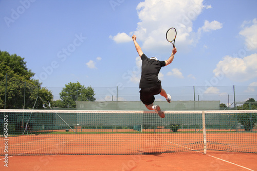 Foto: Spiel, Satz und Sieg - Tennisspieler springt über`s Netz Spiel, Satz und Sieg - Tennisspieler springt über`s Netz