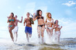happy teenagers playing at the sea