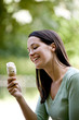 A young woman sitting outdoors, holding an ice cream