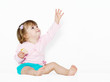 The little girl with the stretched hand on a light background