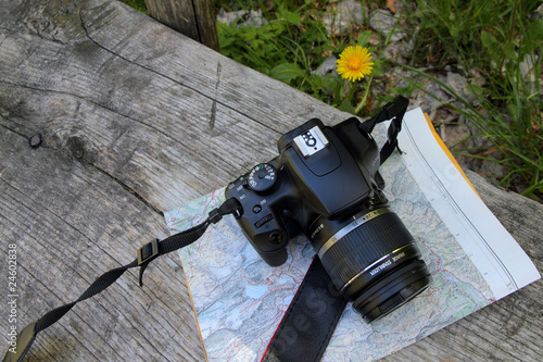 Photo: camera and map on a bench outside camera and map on a bench outside