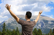 Photo: Man standing in nature with arms lifted up Man standing in nature with arms lifted up
