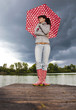 mädchen mit rotweissen regenschirm vor gewitterfront mädchen mit rotweissen regenschirm vor gewitterfront