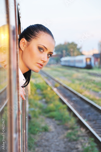 Photo: beautiful young lady looking outside the train beautiful young lady looking outside the train