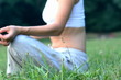 Woman sitting on the grass in park and meditating, dolly shot