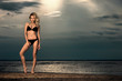 Foto: Young woman on beach in bikini. Young woman on beach in bikini.