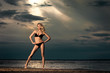 Foto: Young woman on beach in bikini. Young woman on beach in bikini.