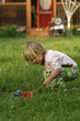 Little blond girl playing in garden
