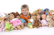 Bub mit Puppen und Kuscheltieren