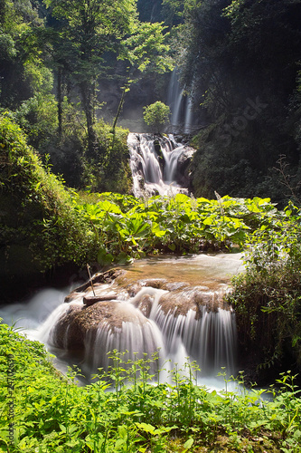 Waterfall cascade. Cascade of falls bordered by trees and rocks Waterfall cascade. Cascade of falls bordered by trees and rocks