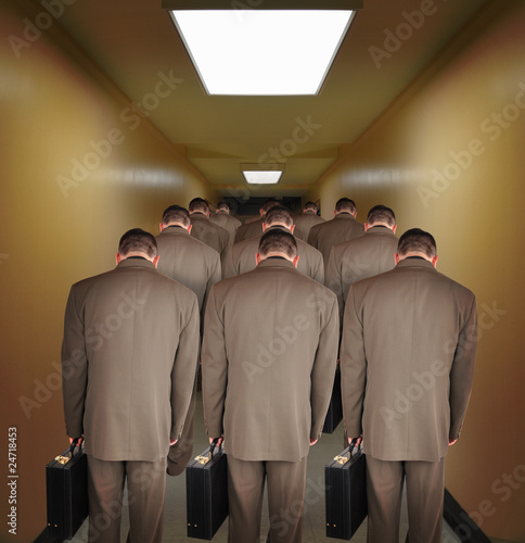 Photo: Overworked Business Men Walking down Hallway Overworked Business Men Walking down Hallway