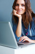Smiling young female using laptop