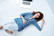 Beautiful young lady relaxing on floor by laptop
