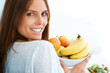 An attractive young woman holding a fruit bowl