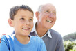 Cute small boy looking away with his grandfather - Outdoor