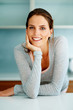 Smart young woman standing at the kitchen counter