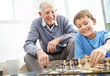 Photo: Grandfather and his grandson playing chess together Grandfather and his grandson playing chess together