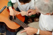 Photo: Old man man helping his young grandson to play guitar Old man man helping his young grandson to play guitar