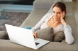 An attractive young woman at home with a laptop