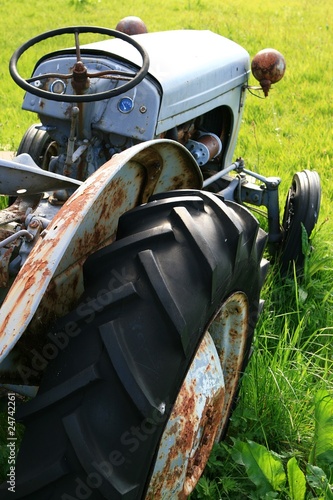Foto: Rostiger Oldtimer Traktor auf einer grünen Wiese Rostiger Oldtimer Traktor auf einer grünen Wiese
