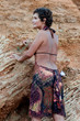 brunet woman in brow dress among rocks