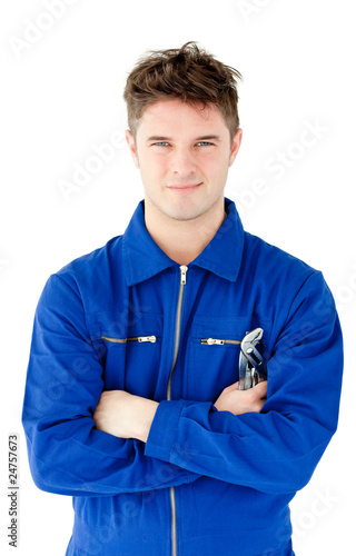 Photo: Charismatic mechanic holding tool smiling at the camera Charismatic mechanic holding tool smiling at the camera