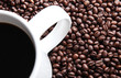 Coffee mug sitting on fresh coffee beans, closeup Coffee mug sitting on fresh coffee beans, closeup