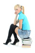 sad schoolgirl sitting on stacked books