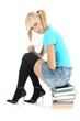 cute schoolgirl sitting on stacked books