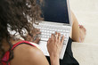 Photo: Young female typing on laptop at home Young female typing on laptop at home