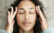 Photo: Young female with headache and massaging her temples Young female with headache and massaging her temples