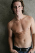 Photo: Portrait of bare chested young male against wall in bathroom Portrait of bare chested young male against wall in bathroom